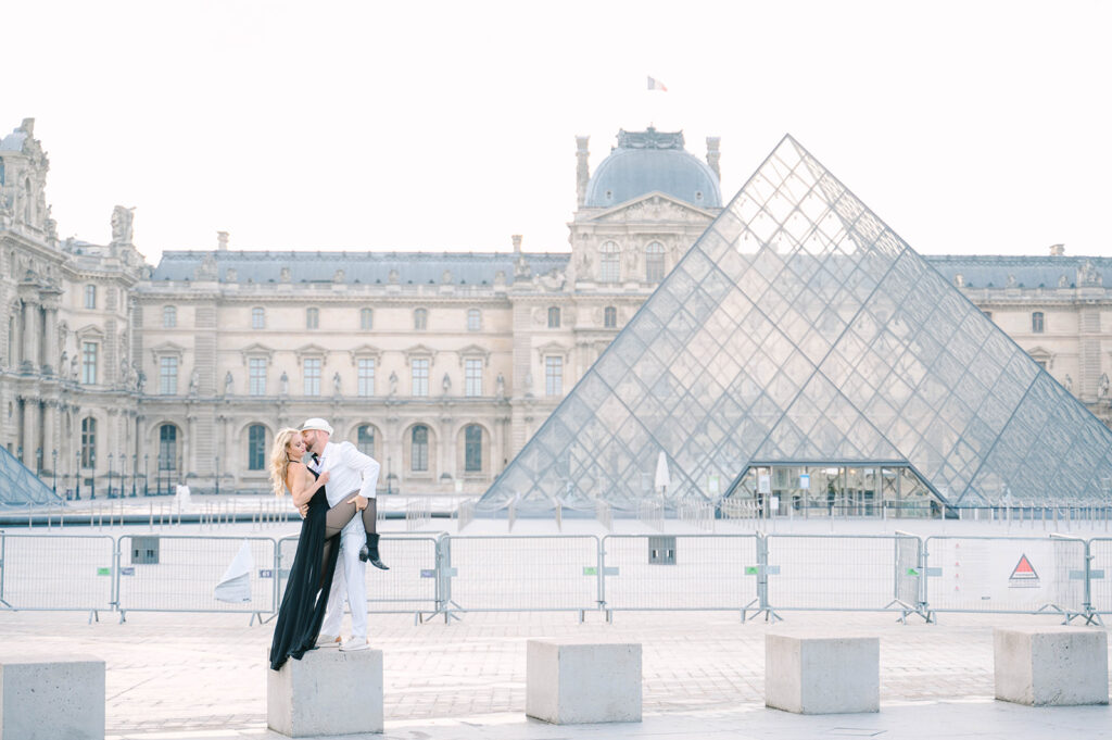 Couple kissing in front of the Louve