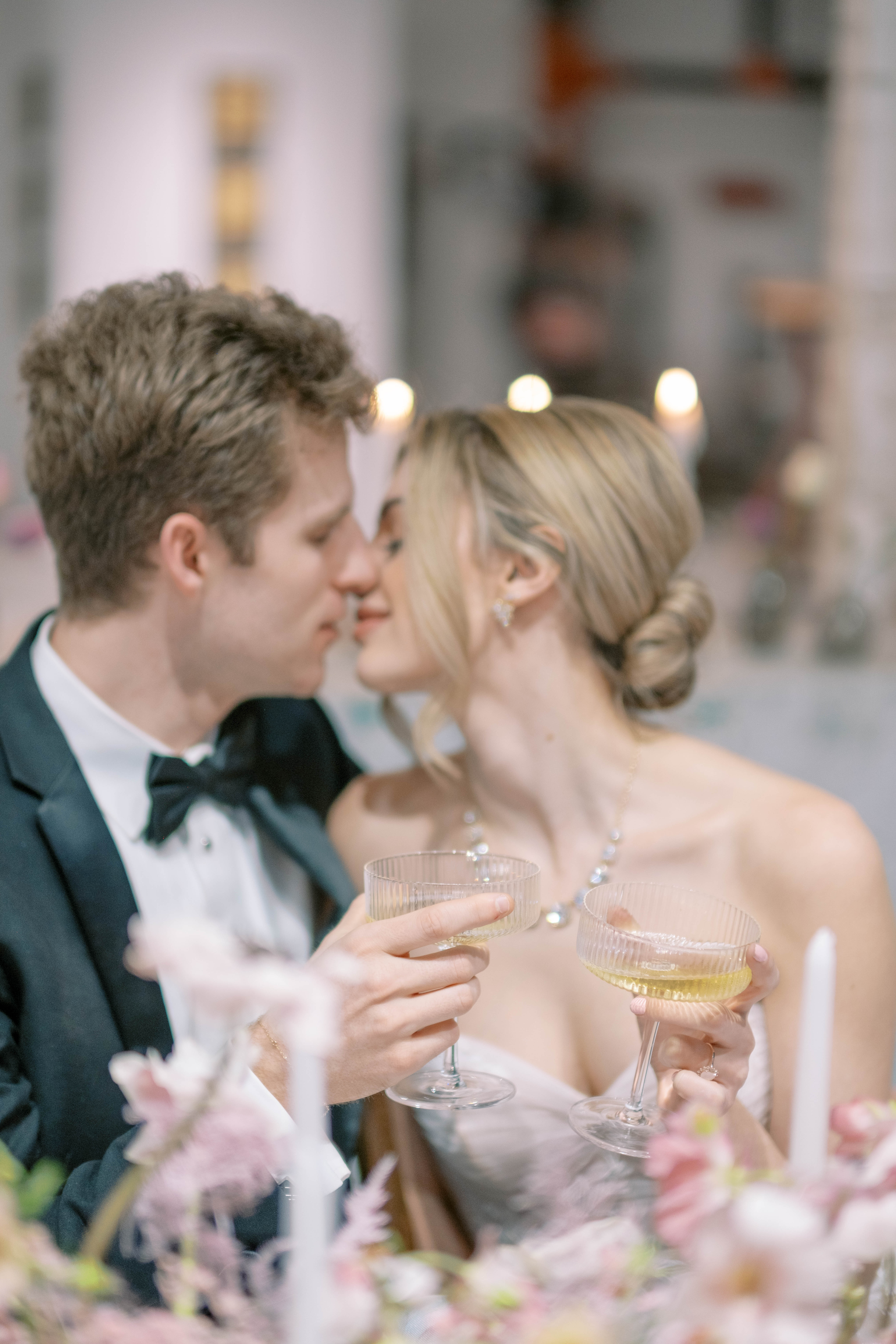 bride and groom about to kiss with champagne glasses in their hands